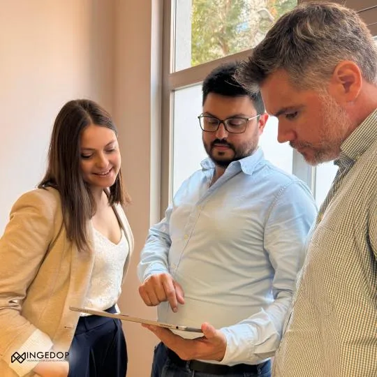 Consultores de Ingedop revisando información estratégica en una tablet durante una reunión.