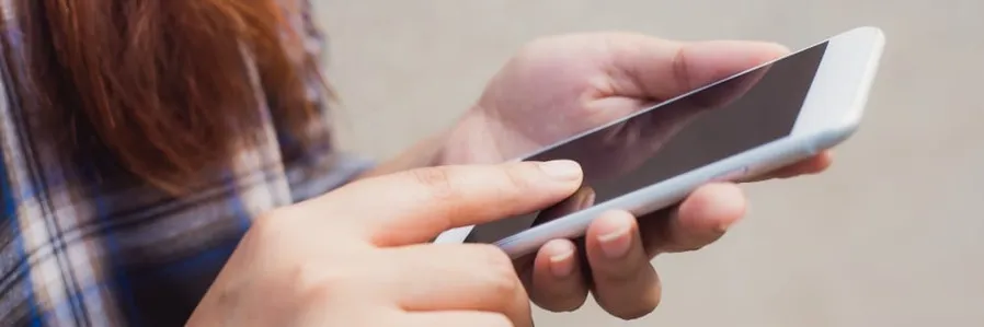 Persona usando un smartphone para gestionar cuentas de redes sociales.